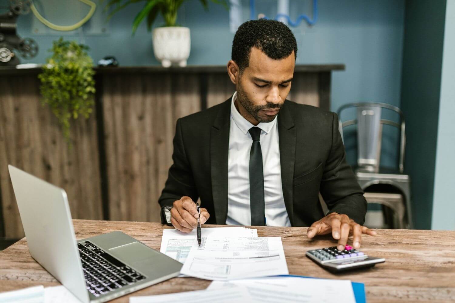 Accountant going through paperwork with a laptop and calculator