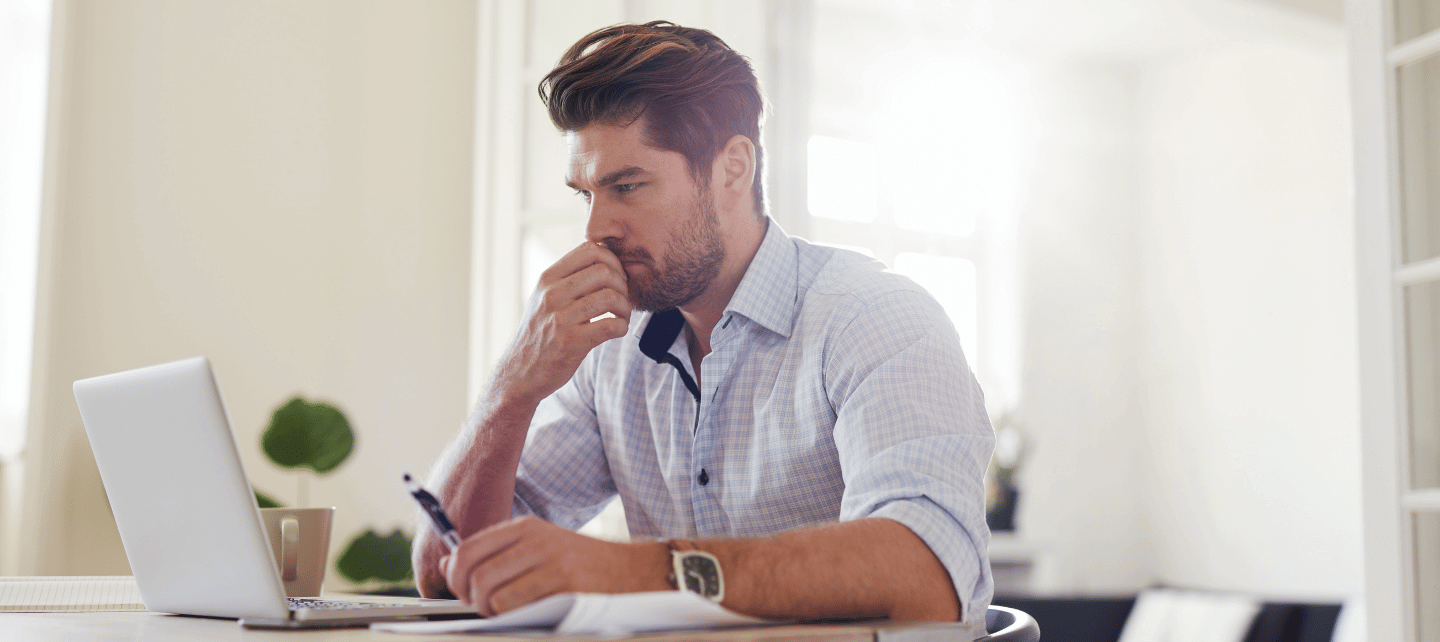 Man contemplating whilst looking at a laptop