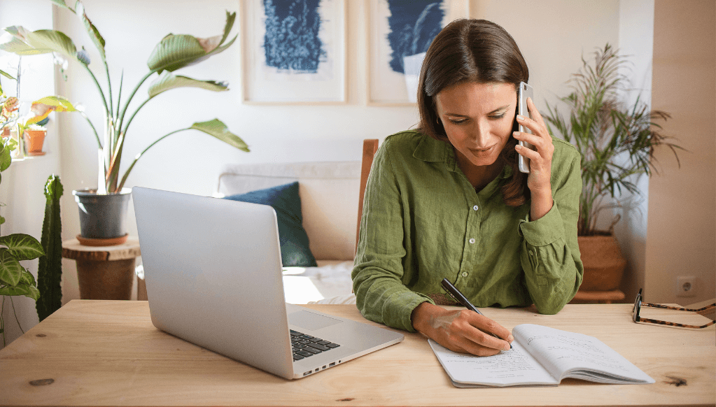 Woman on the phone making note of an insurance quote