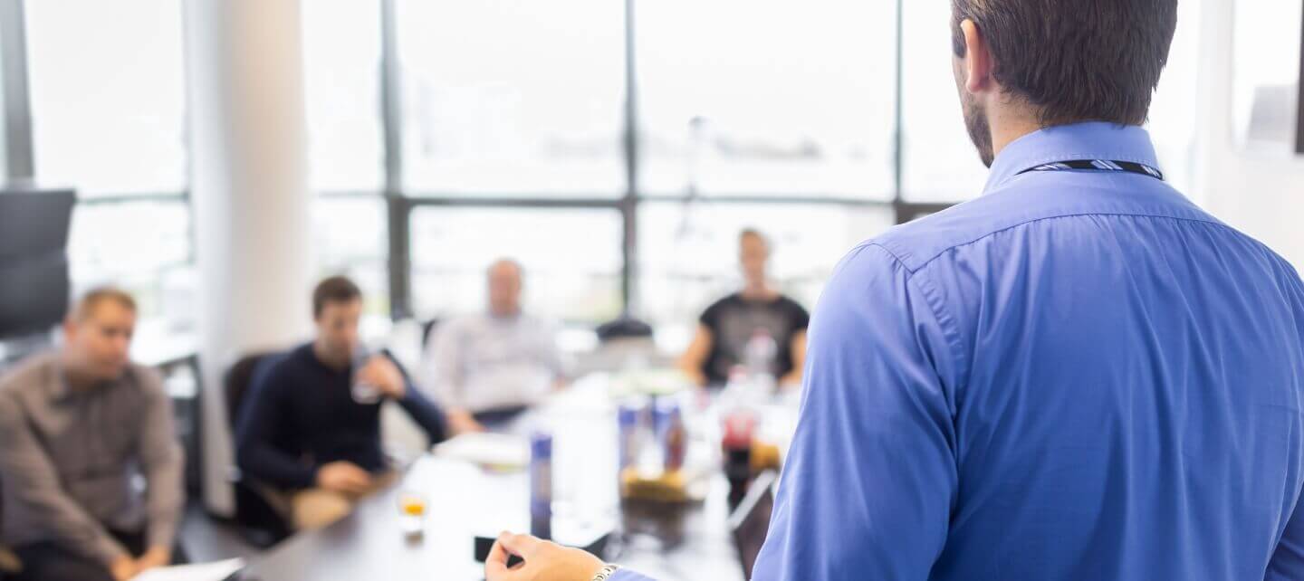 Business professional presenting IR35 Green Card proposal to a team in a modern office setting.