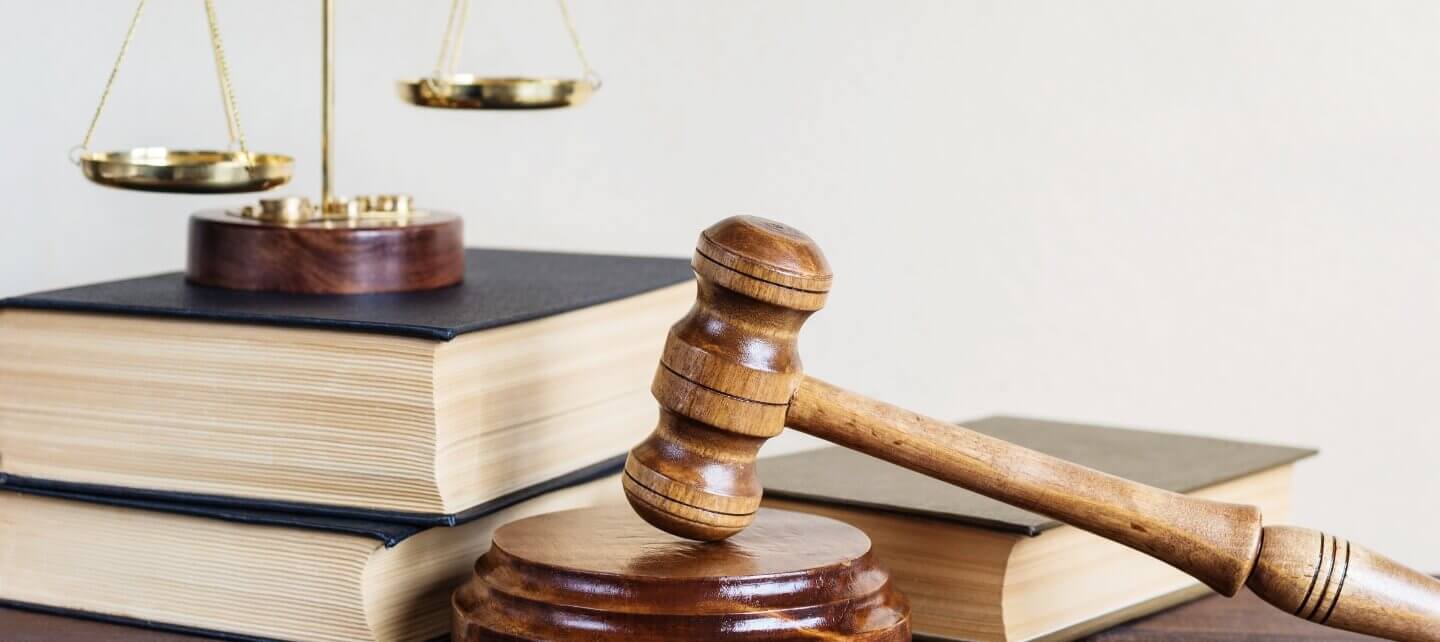 Wooden judge’s gavel resting on a sound block, with legal books and scales of justice in the background, symbolising IR35 tribunal rulings and legal decisions.