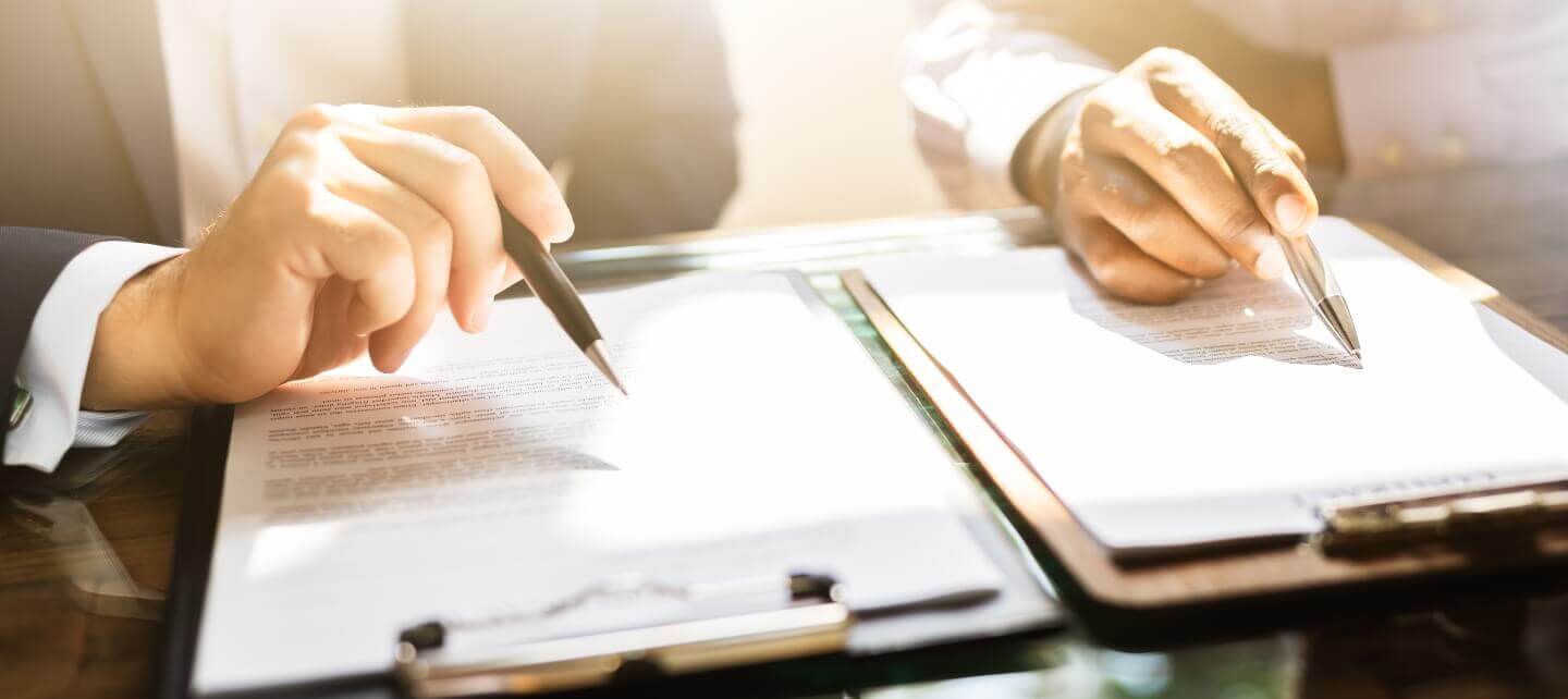 Two professionals reviewing legal documents related to IR35 status and HMRC ESM update