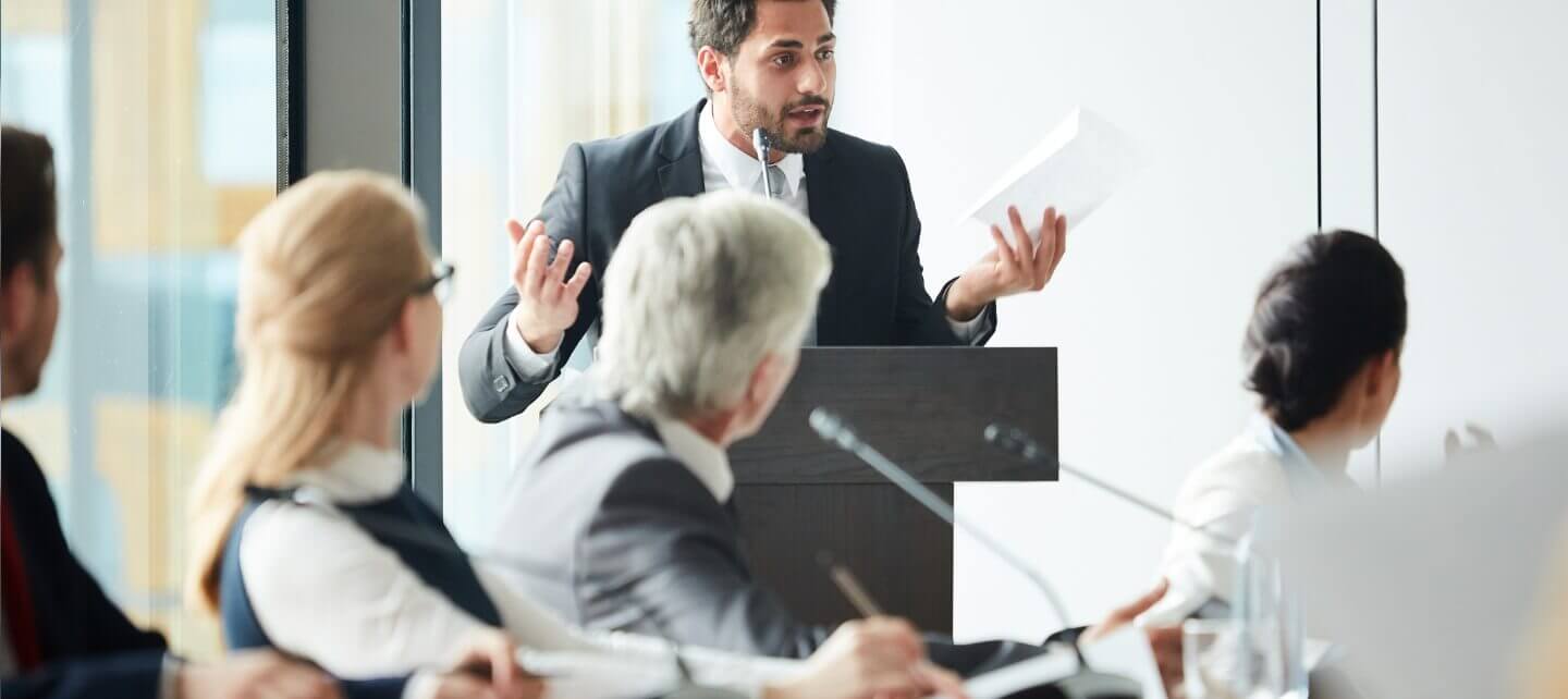 Business professionals debating tax policy at a conference, representing IR35 experts challenging HMRC's off-payroll research.