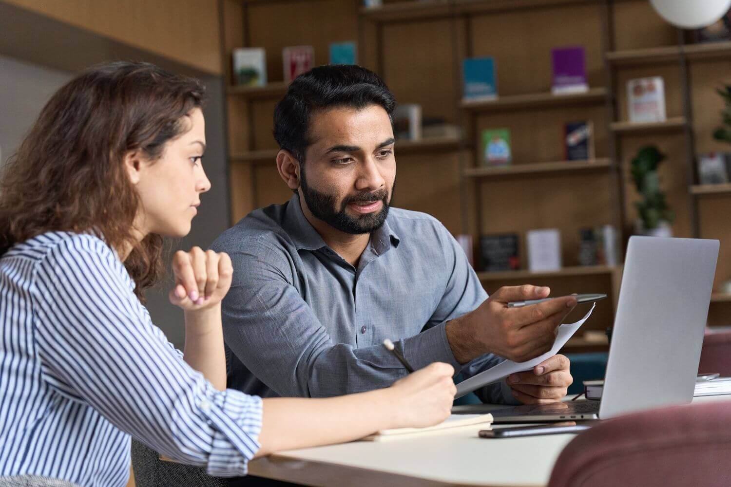 Two professionals having a discussion, representing experts commenting on new HRMC Umbrella Legislation and clearer guidance that umbrella companies need before Autumn Budget 2025