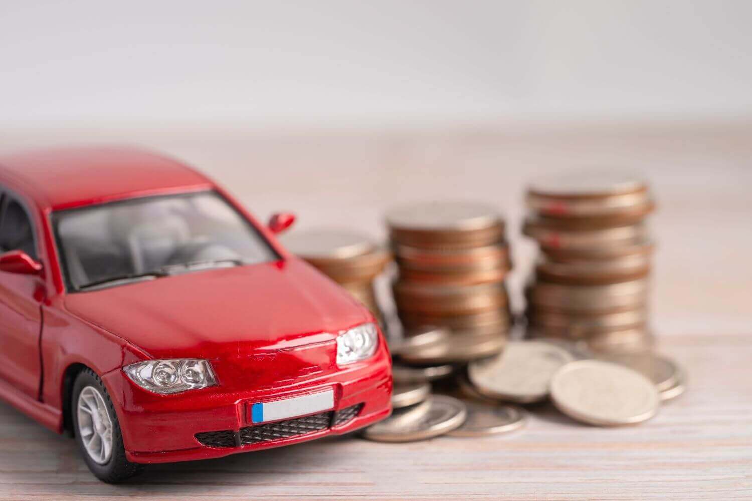 Red car next to stacked coins, representing British Car Auctions IR35 tribunal outcome