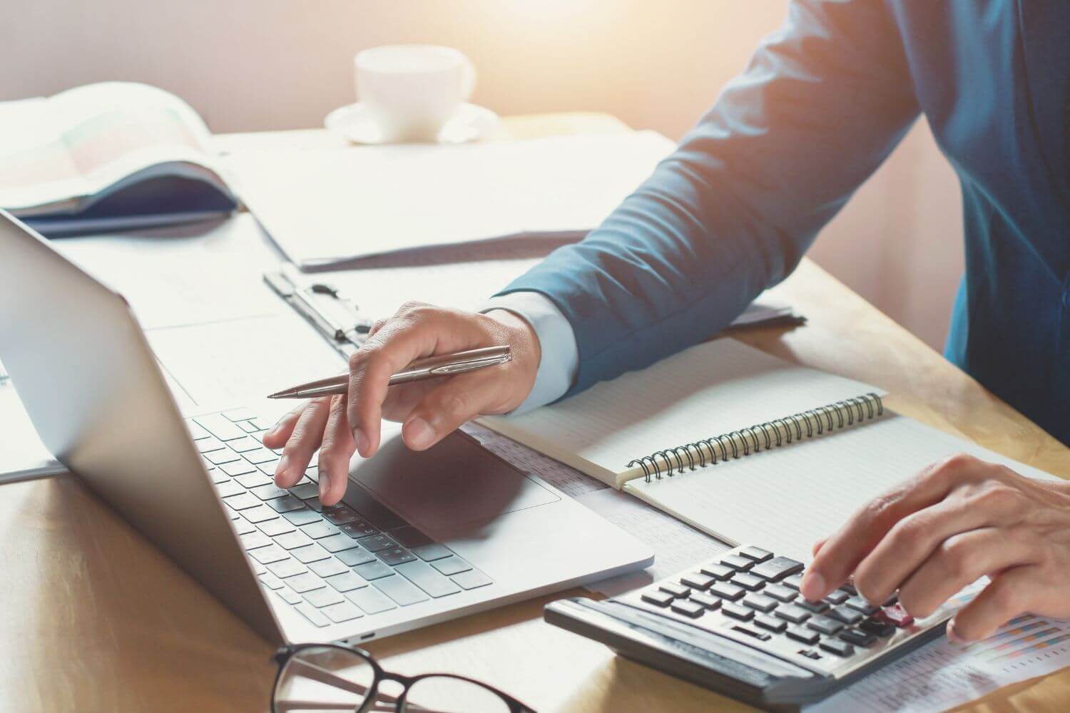 Image of laptop and calculator representing article on tax rules applying to PSCs as a result of joint and several liability, discussed by expert Roger Sinclair