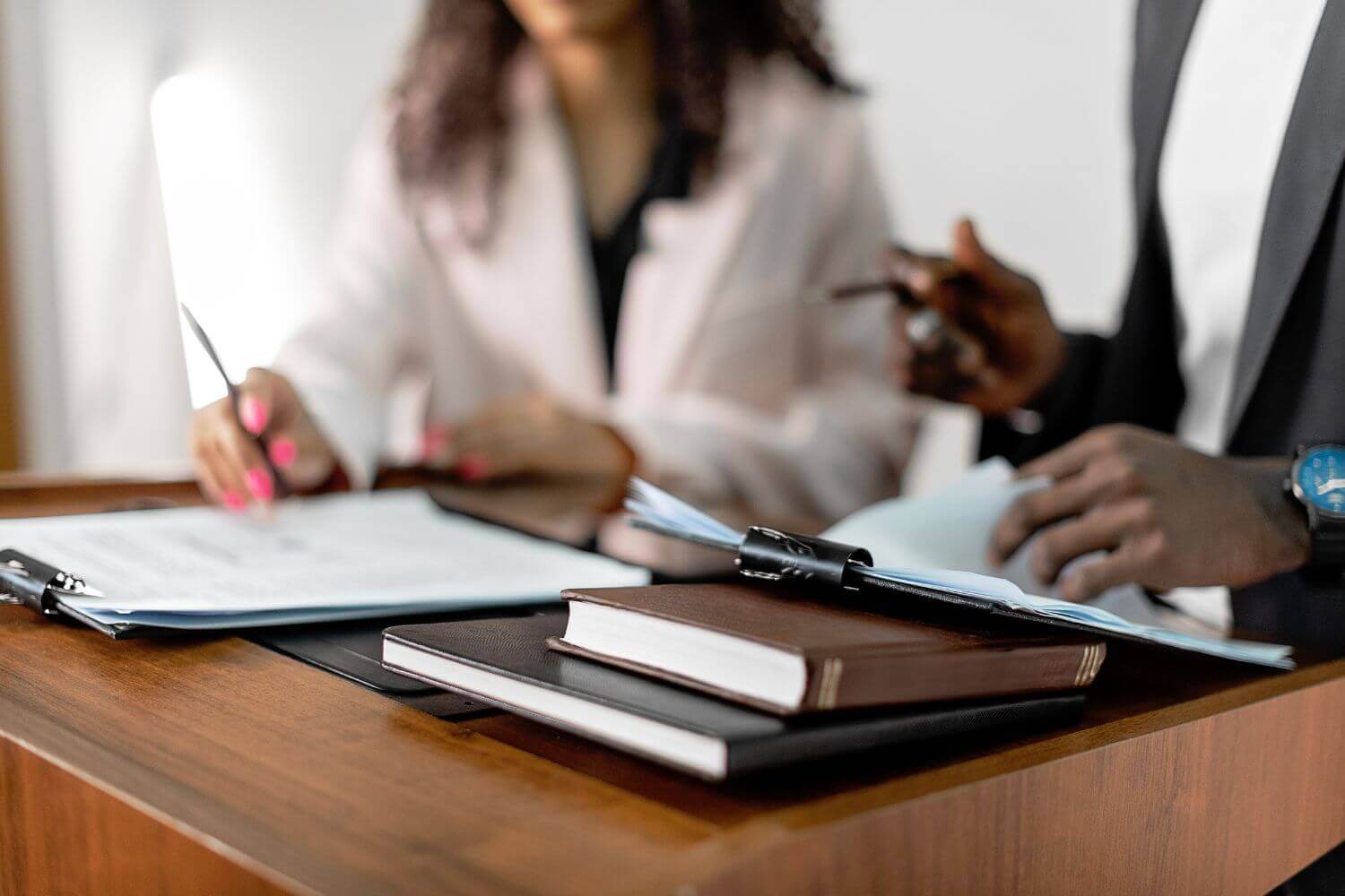 Image of two people study documents. Representing experts discussing the new umbrella company tax rules and the potential to 'refire' outside IR35 roles