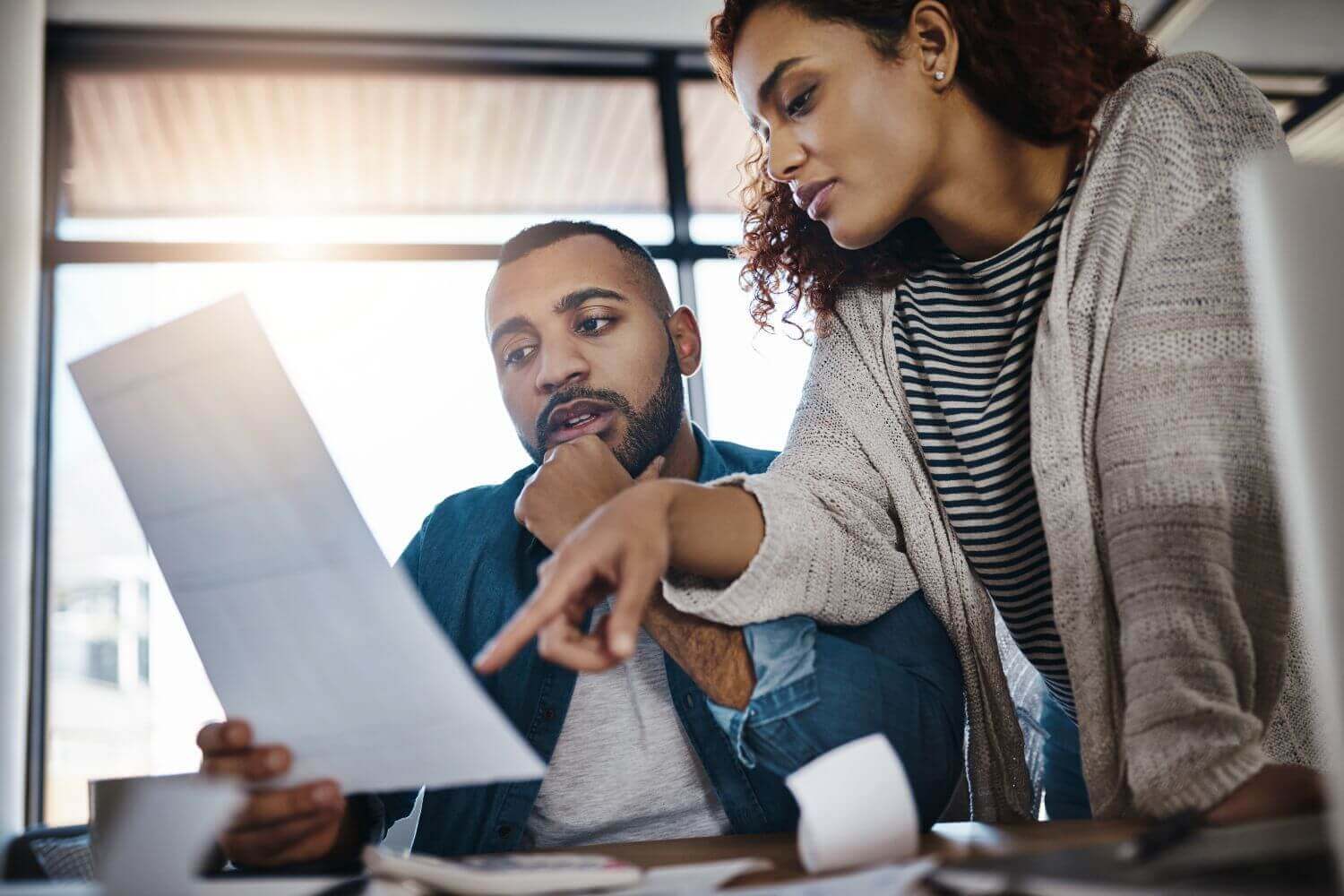 Image of two people discussing a document, representing an business insurance glossary article explaining common insurance terms
