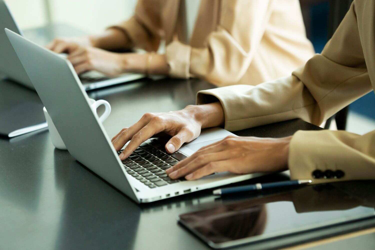 Image of two office workers using laptops, representing IR35 experts discussing the draft umbrella tax legislation 2026 and the impact on recruitment agencies