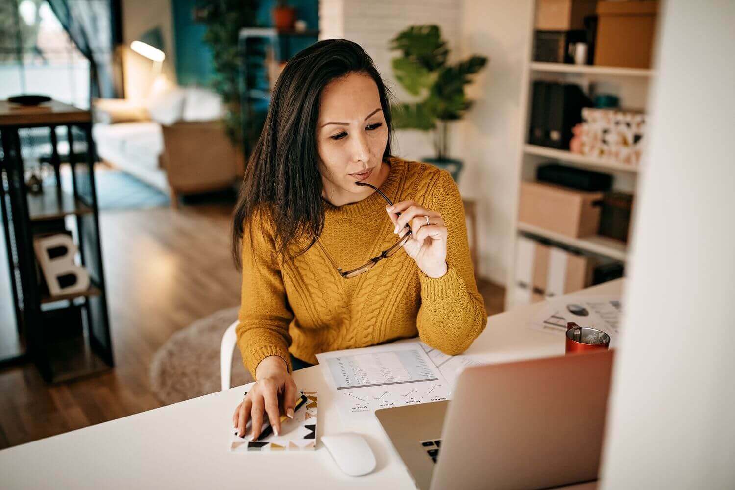 Image of worker at office desk contemplating a document, representing new business insurance checklist and what insurance you need to start a business