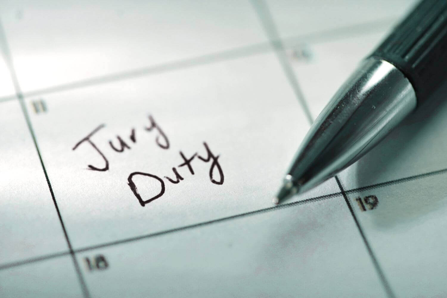 Image of calendar date with "Jury Duty" handwritten inside, representing article discussing jury duty and impact of loss of earnings on the self-employed