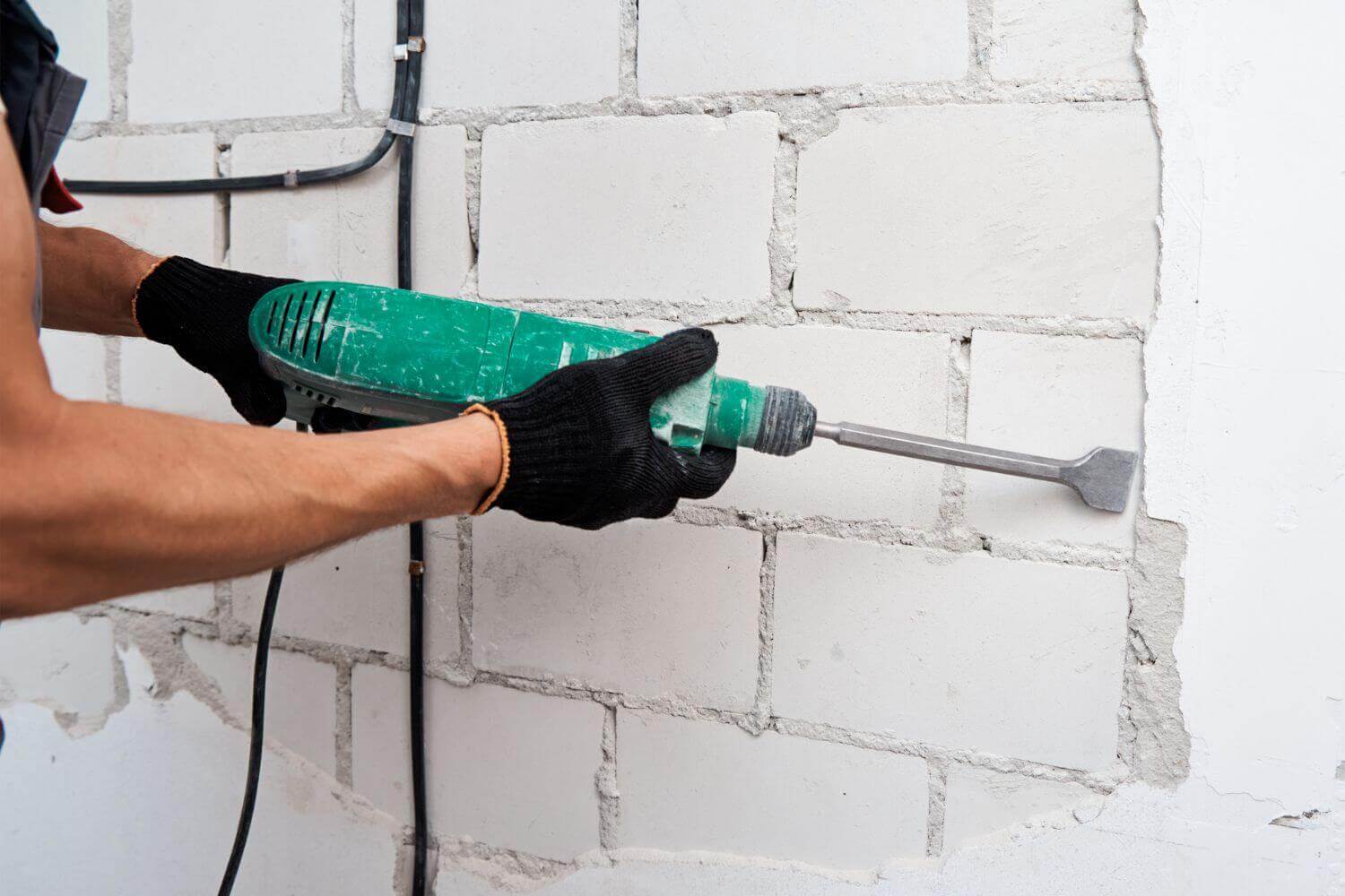 Image of tradesmen using a demolition hammer representing article public liability insurance for trades