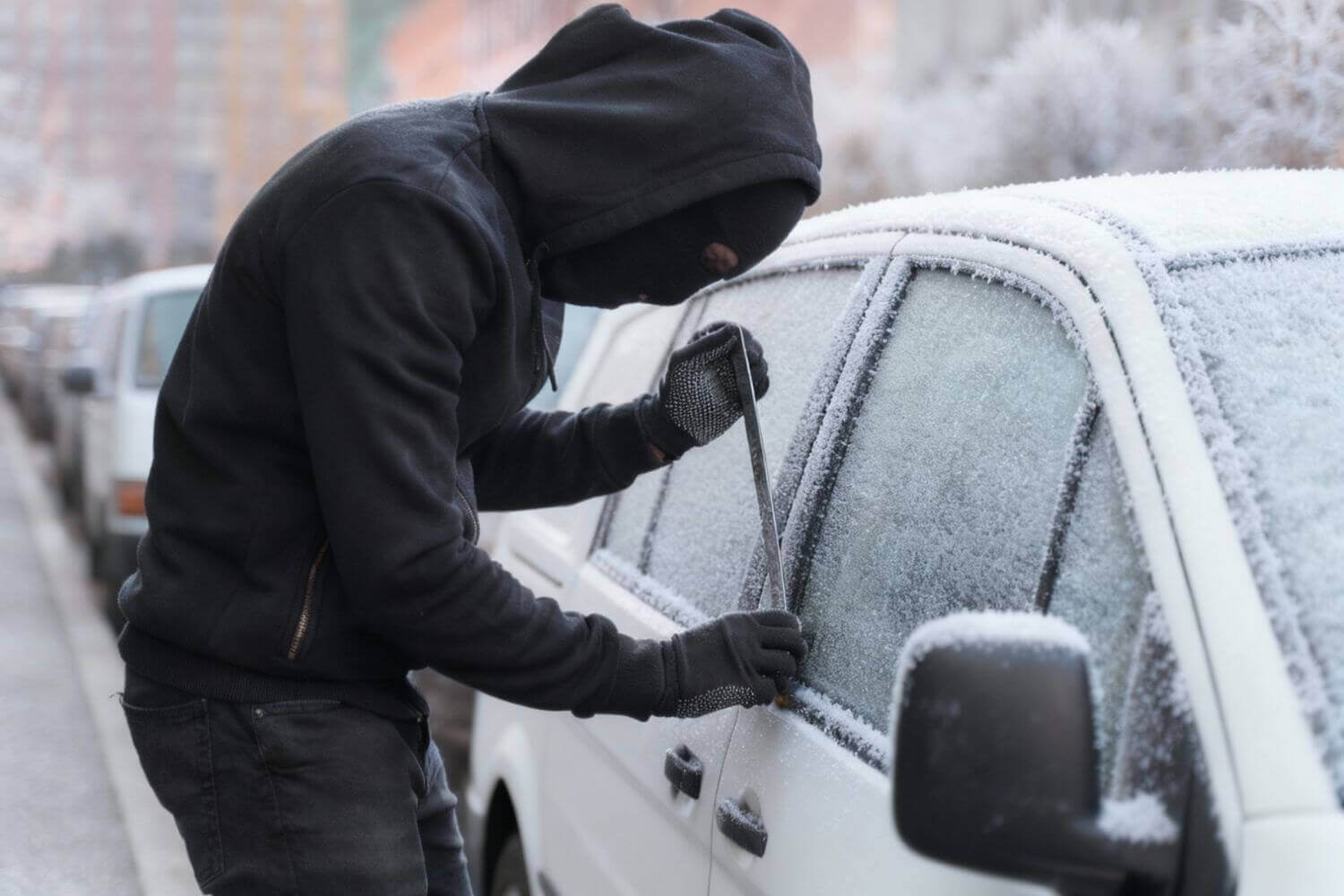 Image of thief breaking into a snowy van, representing article outlining tips on tool theft prevention in winter