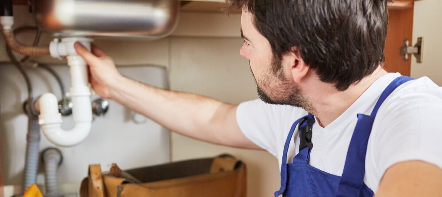 Tradesperson carrying out plumbing work as part of a small business, highlighting the need for appropriate business insurance