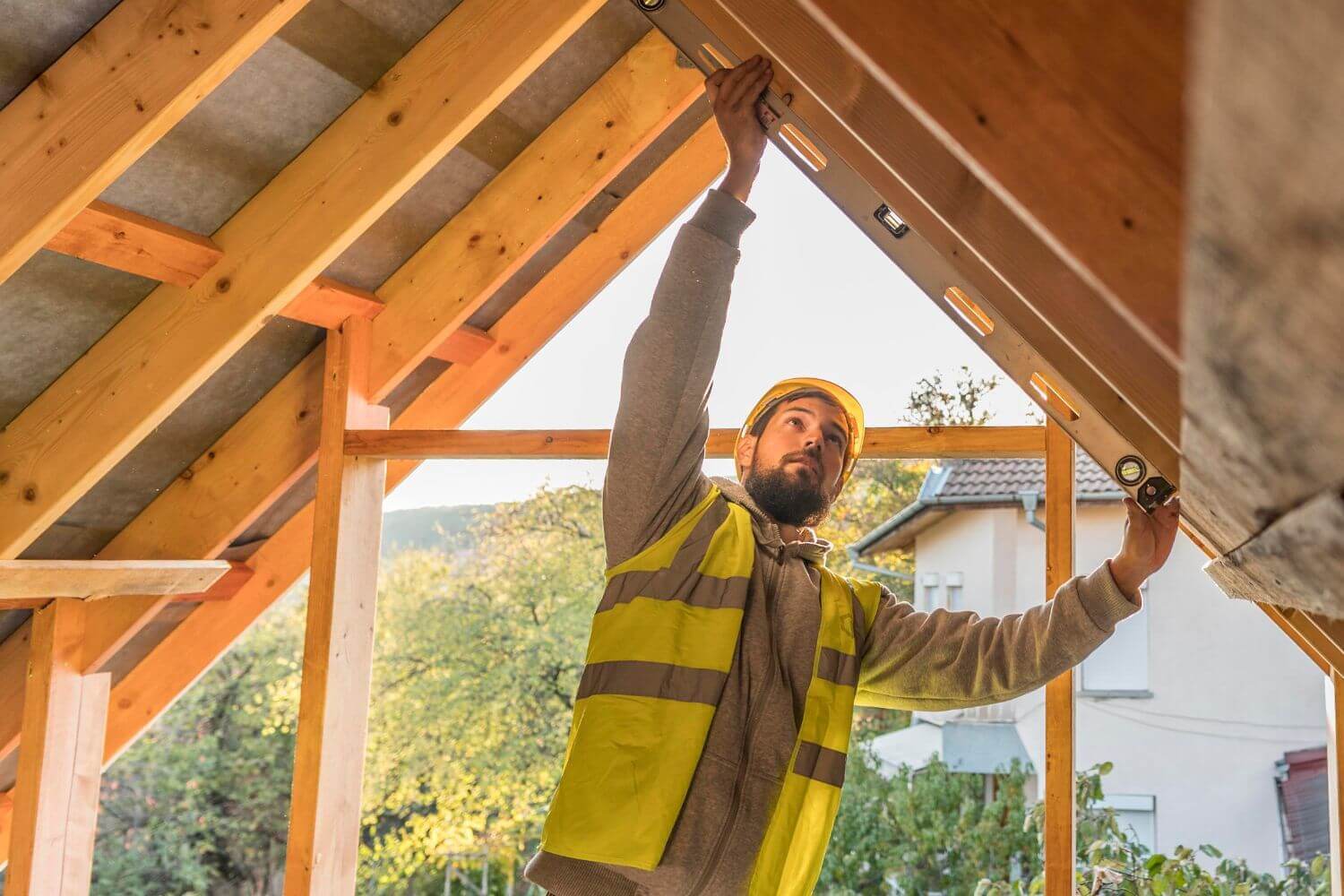 Builder working on a house extension roof, representing a guide to contract works insurance for tradespeople including what it covers
