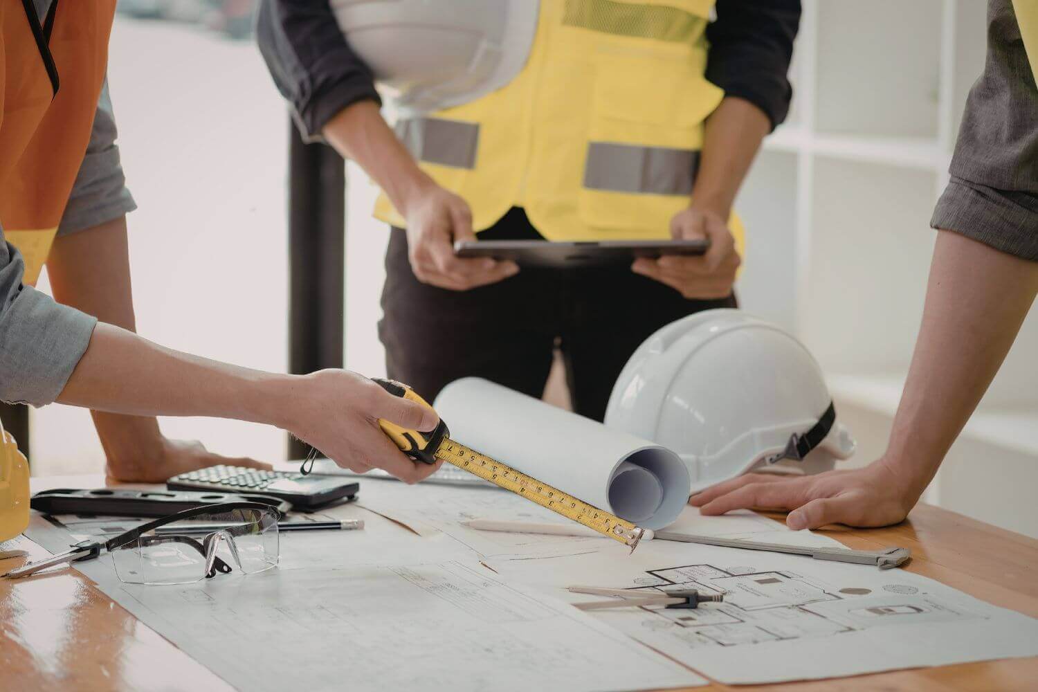 Photo of builders discussing construction plans, representing article on what professional indemnity means for tradespeople