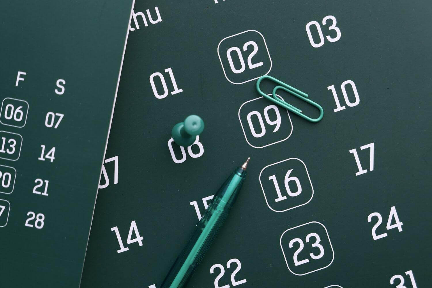 Close-up of dates on a green calendar, representing article discussing claims made vs claims occurring in business insurance